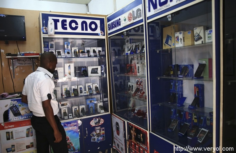 绝对没想到!在非洲最火的国产手机居然是它(图3) A man looks at smartphones on display at a shop at Wuse II business district in Abuja December 9, 2014. Nigeria is suffering from a plummeting currency, steep budget cuts, corruption scandals and diving oil prices; yet all this is unlikely to decide a tight race for the presidency. When the central bank devalued the naira last month to save foreign reserves, the impact was felt instantly on the streets. Nigeria imports 80 percent of what it consumes. Picture taken December 9, 2014. REUTERS/Afolabi Sotunde (NIGERIA - Tags: BUSINESS POLITICS) - RTR4I0KF