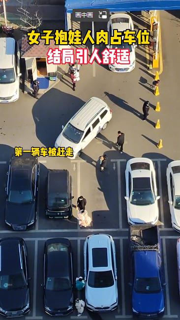 女子抱娃人肉占车位 还移走路障为自家车开路 结局引人舒适